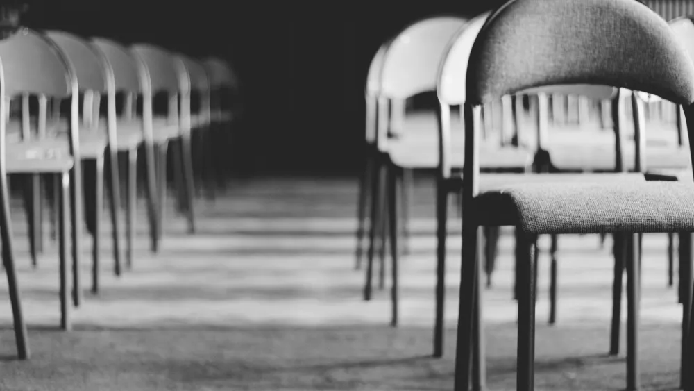 Rows of empty chairs in a meeting hall. Credit: Paweł L./Pexels.