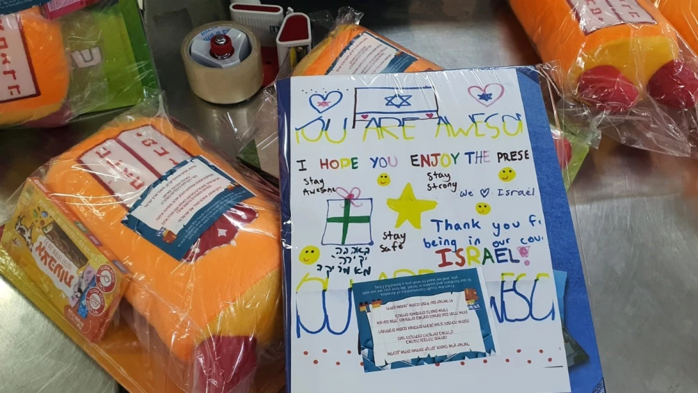 Gifts for children taking shelter from the barrage of rockets that have been fired at Israel from the Gaza Strip were assembled at the Pantry Packers Volunteer Center in Jerusalem and included handwritten notes from day-school students in the United States. Credit: Courtesy.