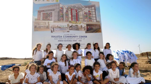 Children of Halutza sit in front of the site of the new state-of-the-art Halutza Community Center. Credit: Jewish National Fund-USA.