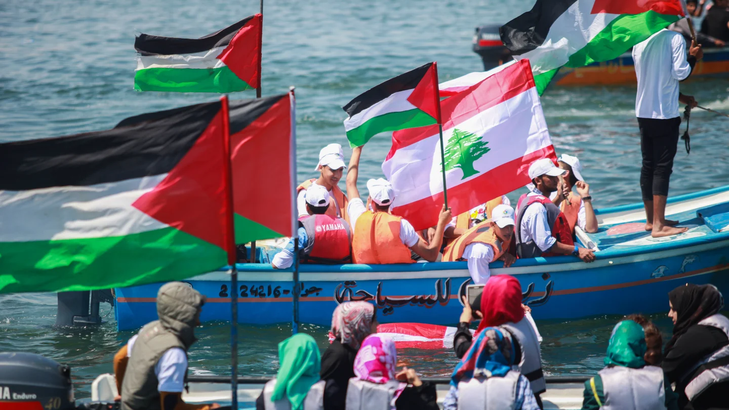 Palestinians hold flags as they ride a boat during a rally marking the fifth anniversary of the "Mavi Marmara" flotilla at the seaport of Gaza City on May 31, 2015. Credit: Aaed Tayeh/Flash90.