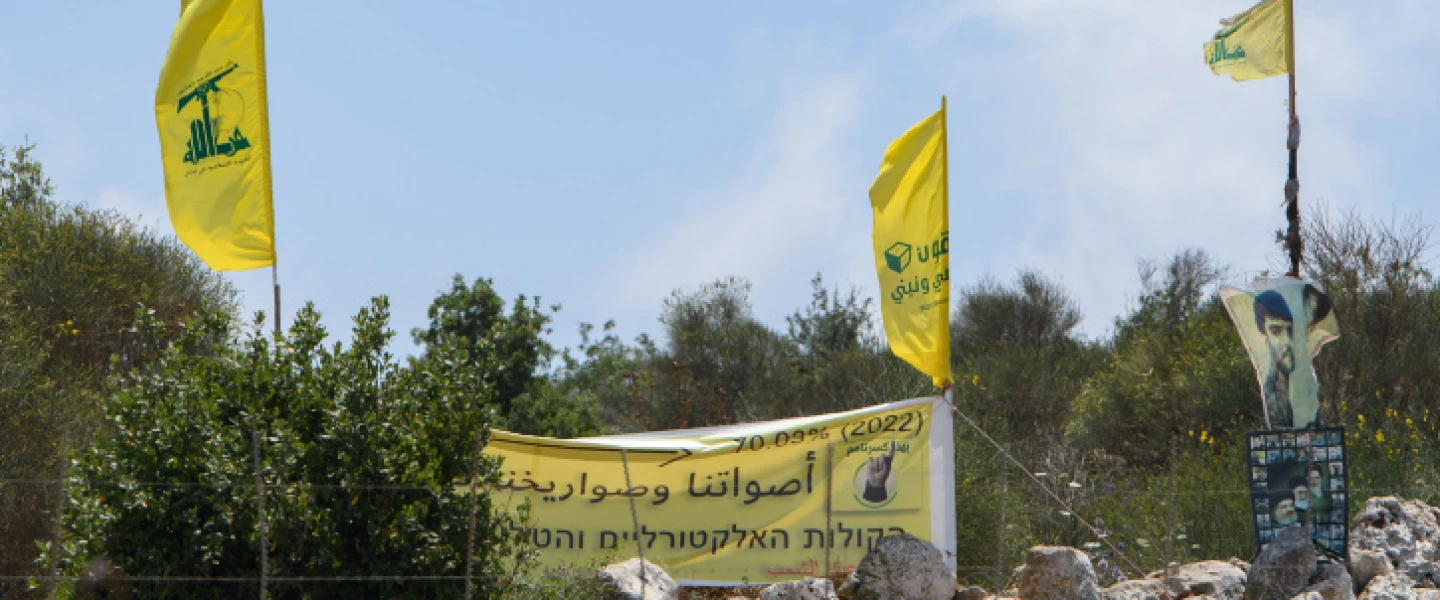 Hezbollah operatives in Lebanon raise the movement's banners at the Israeli border, July 3, 2022. Credit: Ayal Margolin/Flash90.
