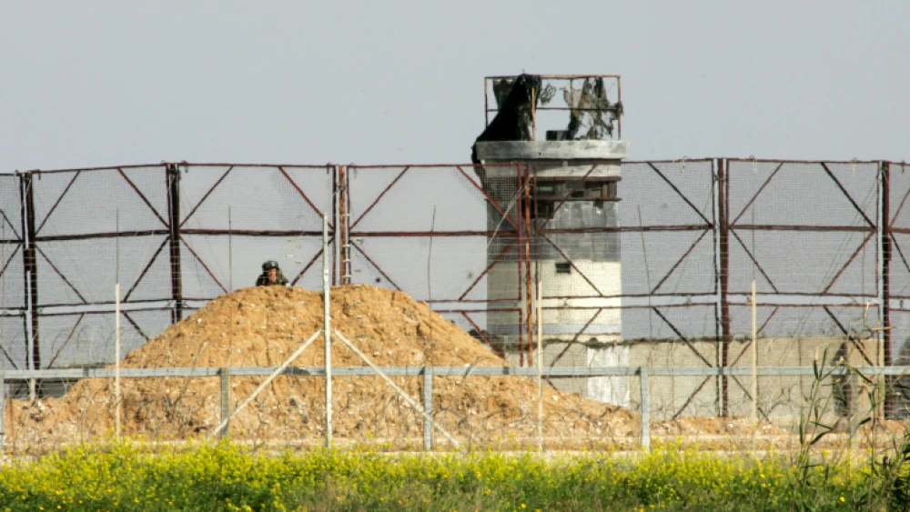 An Israeli soldier watches Palestinian protesters during clashes near the Israel-Gaza border east of Khan Younis in the southern Gaza Strip, March 2, 2018. Photo by Abed Rahim Khatib/Flash90.