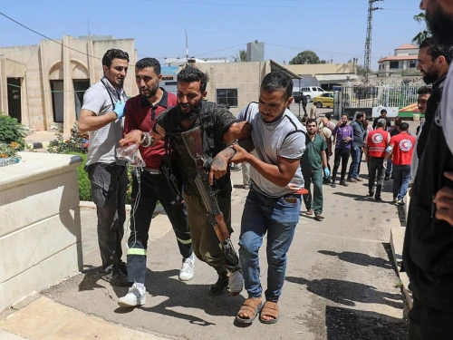 A Bedouin tribal gunman is helped to a hospital in Izra, in Syria's southern Daraa Province, after being wounded in combat against Druze fighters in nearby Sweida on July 19, 2025. Photo by Abdulaziz Ketaz/AFP via Getty Images.