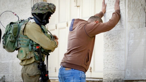 An Israeli soldier performs a body search on a Palestinian man in Hebron, Nov. 4, 2016. Photo by Wisam Hashlamoun/Flash90.