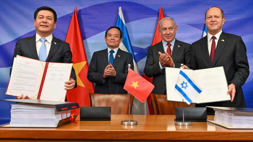 Vietnamese Minister of Industry and Trade Nguyen Hong Dien and Israeli Economy Minister Nir Barkat hold copies of a signed free trade agreement at the Prime Minister's Office in Jerusalem as Prime Minister Benjamin Netanyahu and Vietnamese Deputy Prime Minister Tran Luu Quang applaud, July 25, 2023. Photo by Kobi Gideon/GPO.
