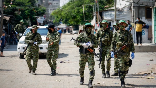 Palestinian fighters in the Izz ad-Din al-Qassam Brigades, the armed wing of the Hamas terrorist organization, distribute protective masks on the street amid the COVID-19 pandemic, in Rafah in the southern Gaza Strip, on Sept. 10, 2020. Photo by Abed Rahim Khatib/Flash90.