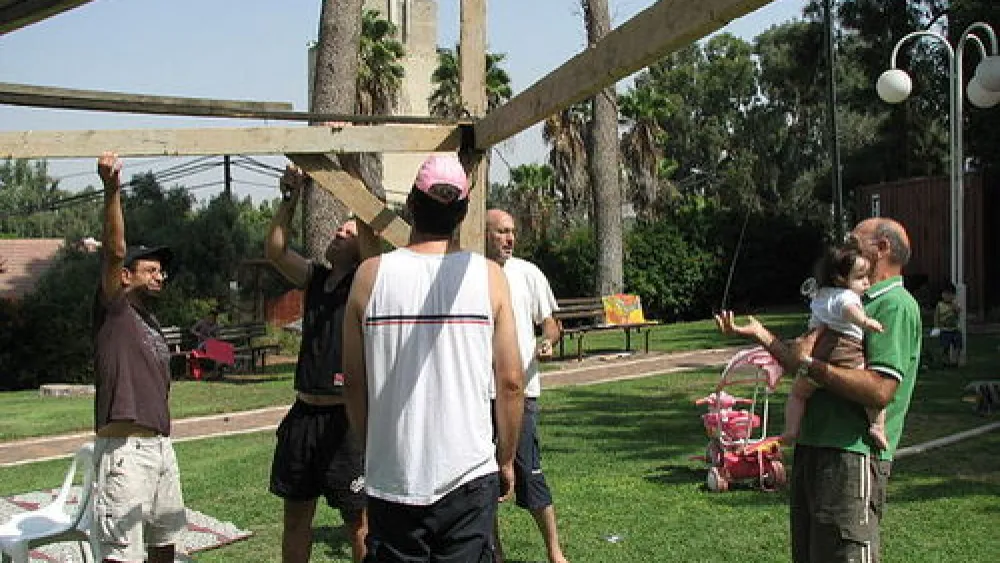 The construction of a sukkah in Ramat Hacovesh, Israel. One possible advantage of renting a sukkah over owning one is avoiding the process of putting up and taking down the sukkah yourself. Credit: PikiWiki - Israel free image collection project.