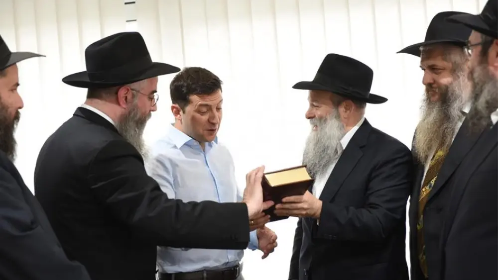 President-elect Volodymyr Zelenskyy, Ukraine's first-ever Jewish president, held a high-profile meeting with Ukraine's regional chief rabbis on May 6. Here, the comedian-turned-politician is presented with a Chumash in Russian translation by Rabbi Shmuel Kaminezki and Rabbi Avraham Wolff, as other members of the delegation look on. Credit: Chabad.org/News.