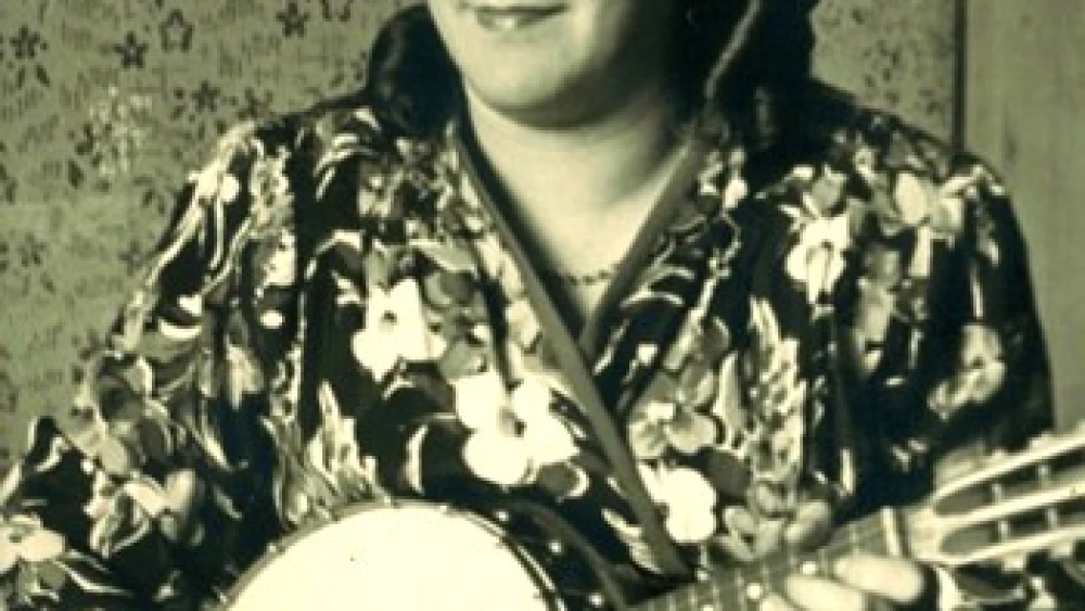 Masha Piotrkowska pose with the mandolin-banjo she got in Bergen-Belsen. Photo courtesy of Gail Levin and Ken Rapoport.