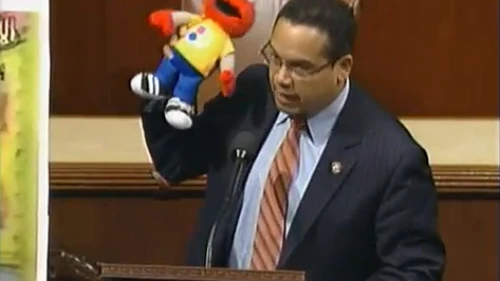 Click photo to download. Caption: Holding Elmo, Congressman Keith Ellison makes the case against defunding Palestinian Sesame Street. Credit: YouTube.