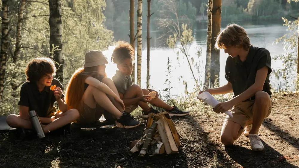 Kids making a bonfire at camp. Credit: Katrin Bolovtsova/Pexels.