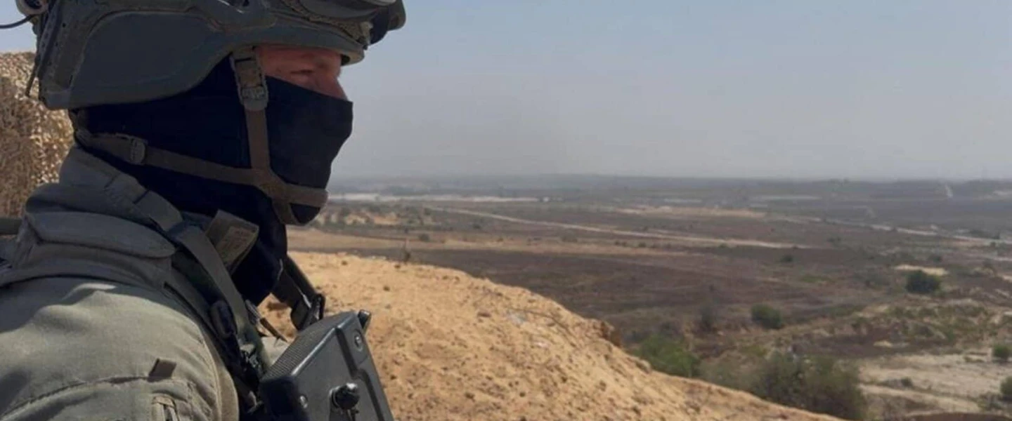 Lt. Col. T., commander of the IDF's 969th Battalion, stands in the northern Gaza Strip and looks down on Beit Hanoun and Kibbutz Kibbutz Kfar Aza, July 17, 2025. Credit: ILTV.