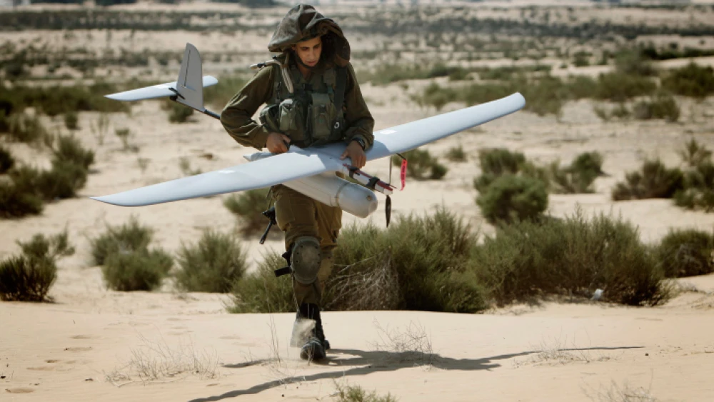 An Israeli soldier carries an unmanned aerial vehicle during a training drill at the Tze'elim army base on Aug. 5, 2013. Photo by Miriam Alster/Flash90.