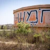 Visitors walk by the water tower in the ruins of the former community of Homesh, Aug. 27, 2019. Photo by Hillel Maeir/Flash90.