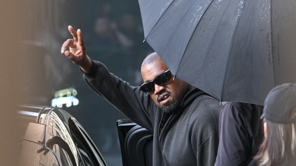 Kanye West gestures upon arriving at Shanghai Pudong International Airport in China on July 11, 2025. Photo by Hector RETAMAL / AFP via Getty Images.