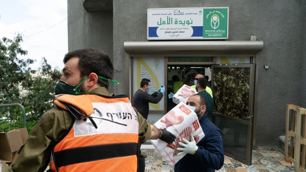 Soldiers in the Israel Defense Forces distribute meals to Israeli-Arab communities. Source: IDF via Twitter.