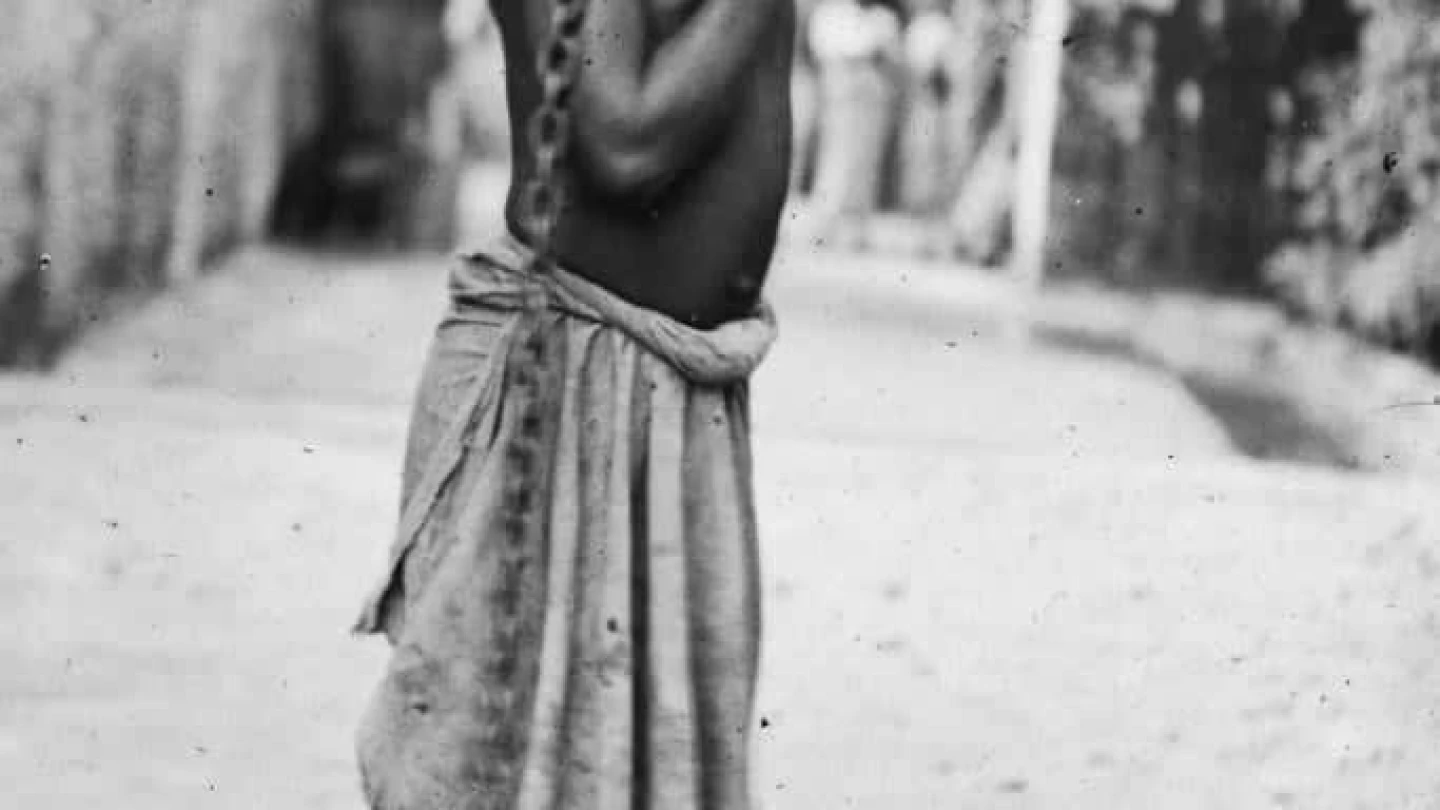 A photograph of an enslaved boy in Zanzibar, circa 1890. The original image states: "An Arab master's punishment for a slight offense." Credit: Public Domain via Wikimedia.