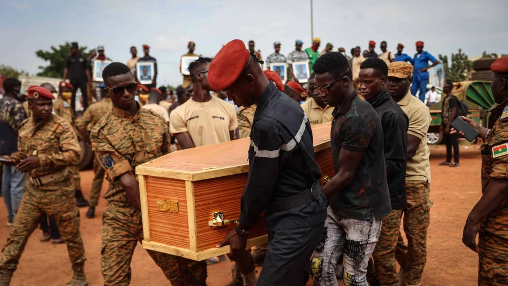 Burkina Faso's servicemen carry a coffin during the burial of the soldiers killed in Gaskinde, in Ouagadougou on Oct. 8, 2022. The ambush in Gaskinde, claimed by Al-Qaeda, officially killed 37 people, including 27 soldiers on Sept. 26, 2022. Photo by Oympia De Miasmont/AFP via Getty Images.