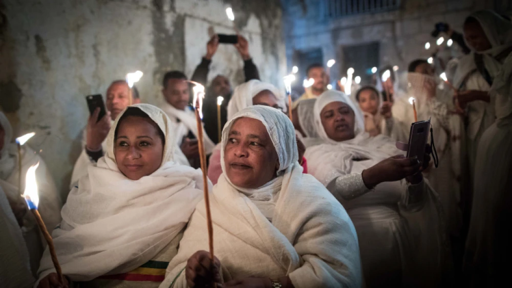 Ethiopian Orthodox Christian worshippers hold candles outside Deir Al-Sultan in the Church of the Holy Sepulcher during the ceremony of the Holy Fire in Jerusalem's Old City, Saturday, April 27, 2019. Photo by Noam Revkin Fenton/Flash90.