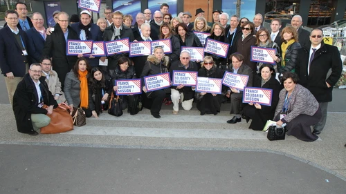 Participants of the Jewish Federations of North America mission to Paris pose in front of the Hyper Cacher kosher grocery in February 2015, where four Jewish shoppers were killed weeks before in an Islamist terror attack. Credit: The Jewish Federations of North America.