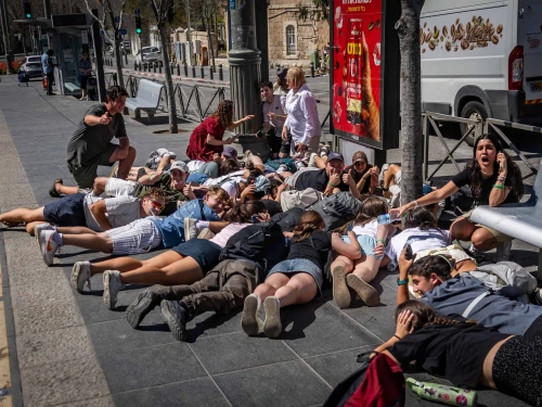 People take cover as sirens warns of incoming missile fire from Yemen in Jerusalem, March 27, 2025. Photo by Chaim Goldberg/Flash90.