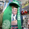 Gaza City, Gaza Strip on Feb. 7, 2006: Palestinian Abu Dayya holds up the Hamas flag in front of a poster of Mahmoud Abbas in his shop in Gaza City. Photo by Ahmad Khateib/Flash90.