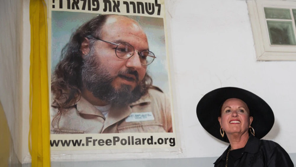 Esther Pollard walks past a poster of her husband, Jonathan Pollard, before speaking to reporters outside of her Jerusalem home on July 29, the day after it was announced that Jonathan, jailed for nearly 30 years over giving Israel classified information on America, will be released in November 2015. Photo by Flash90.