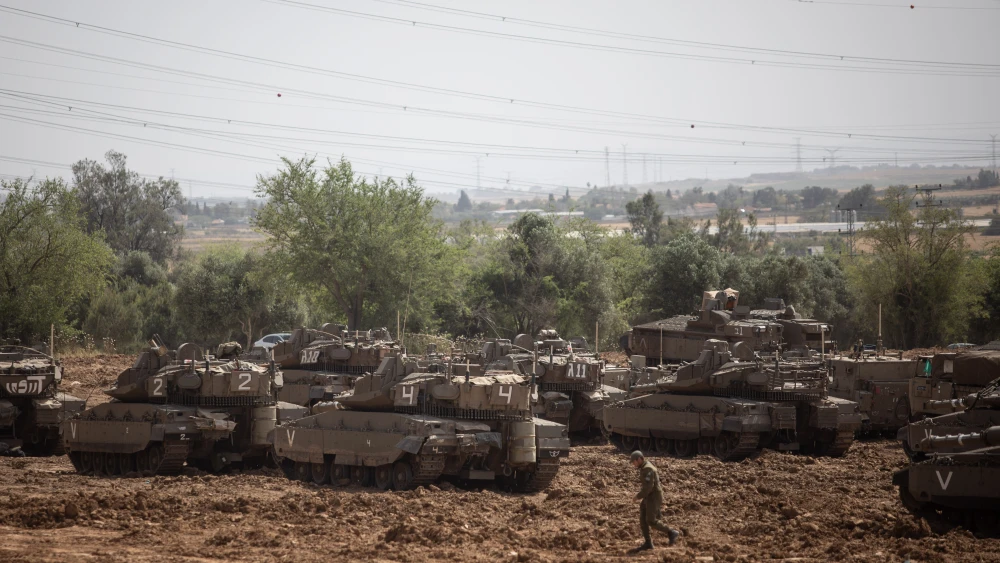 Israeli soldiers seen near IDF tanks stationed near the Israeli Gaza border on May 6, 2019. Credit: Aharon Krohn/Flash90