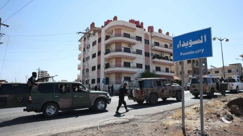 A convoy of Syrian military and security forces passes a sign for Sweida city in Syria, on July 15, 2025. Photo by Stringer/Getty Images.