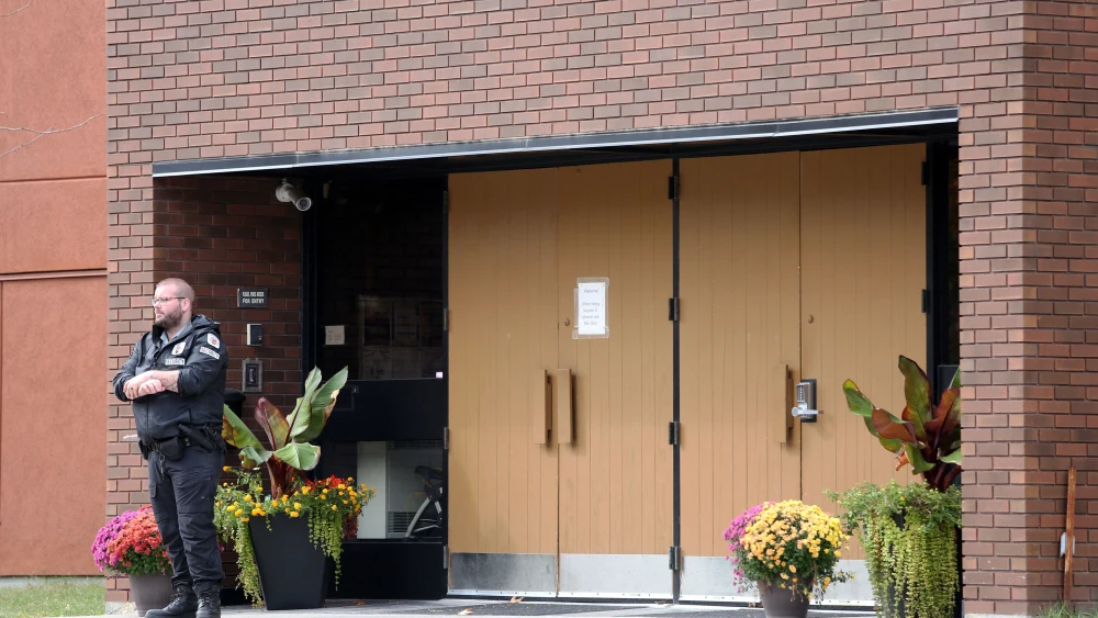 A security guard stands outside the front door of Machzikei Hadas Orthodox synagogue in Ottawa, the day after Hamas's Oct. 7 massacre, Oct. 8, 2023. Photo by Dave Chan/AFP via Getty Images.