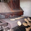 Handmade matzah comes out of the oven. Credit: Ariel Palmon via Wikimedia Commons.