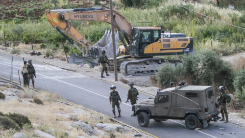 IDF soldiers stand guard as a bulldozer demolishes a Palestinian house that was built without a permit in the village of Beit Dajan, east of Nablus, May 9, 2022. Photo by Nasser Ishtayeh/Flash90.