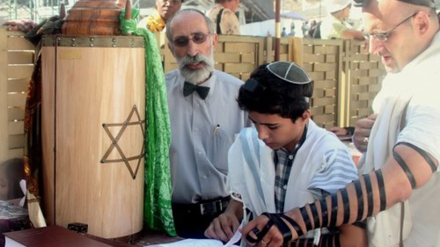 A bar mitzvah boy reads his Torah portion at the Western Wall in Jerusalem. Credit: Peter van der Sluijs via Wikimedia Commons.