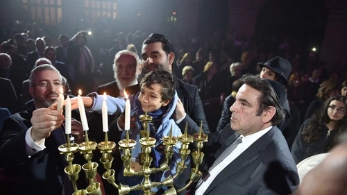 Relatives of the Hyper Cacher terrorist attack victims (Philippe Braham, Yohan Cohen, Yoav Hattab, and François-Michel Saada) light Hanukkah candles at this week's “Let There Be Light: A Concert of Jewish Unity” at the Grande Synagogue de la Victoire (the Great Synagogue of Paris). Credit: Israel Bardugo.