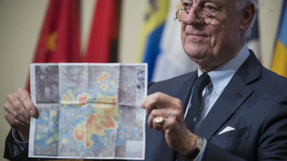 Staffan de Mistura, the United Nations special envoy for Syria, holds up a photo of Aleppo while briefing journalists following a U.N. Security Council emergency meeting on the situation in Syria Dec. 13, 2016. Credit: UN Photo/Amanda Voisard.