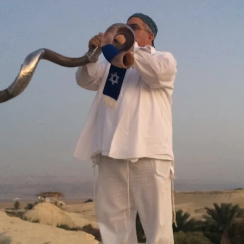 Robert Weinger blowing two shofars in perfect harmony. Source: Screenshot.