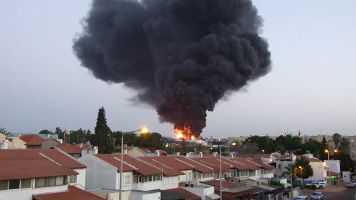 A factory in the southern Israeli city of Sderot bursts into flames after being hit by a rocket from Gaza during the 2014 Hamas-Israel conflict. Credit: Natan Flayer via Wikimedia Commons.