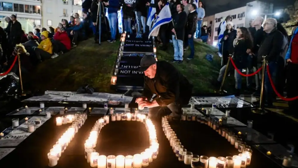 A man lights candles to mark 100 days since the start of the war during a protest against Israeli Prime Minister Benjamin Netanyahu and the current Israeli government, in Tel Aviv, January 13, 2024. Photo by Avshalom Sassoni/Flash90 *** Local Caption *** ????? ?????? ????? ???? ????? ?????