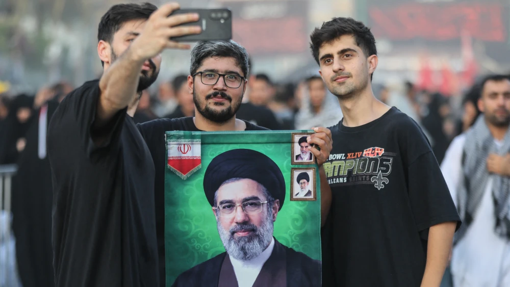 Shia Muslim pilgrims hold a portrait of Iran's Supreme Leader Mojtaba Khamenei as they take a selfie in the holy city of Karbala, Iraq on July 31, 2026. Photo by Karar Jabbar/AFP/Getty Images.