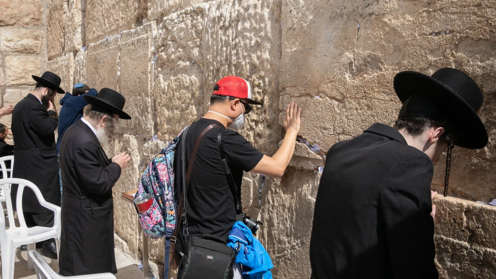An American tourist wearing a face mask for fear of the coronavirus prays at the Western Wall in the Old City of Jerusalem on Feb. 27, 2020. Photo by Olivier Fitoussi/Flash90.