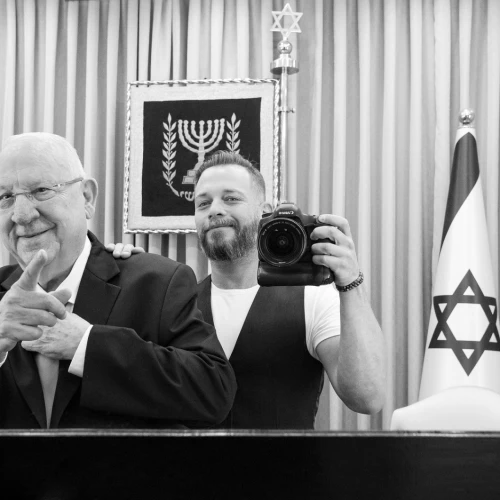 Israeli combat veteran and photographer Lior Nir poses with former Israeli President Reuven Rivlin as part of a pop-up exhibition showing this weekend in New York City to raise awareness of Israeli vets dealing with PTSD. Credit: Mike Wagenheim.