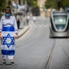 Pedestrians and drivers stand still as a siren sounds across Israel to mark Yom Hazikaron, the country's Memorial Day, which commemorates fallen Israeli soldiers and victims of terror, in Jerusalem on April 28, 2020. Photo by Yonatan Sindel/Flash90.