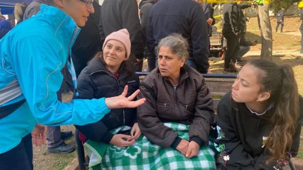 Leora Wine, director of disaster response for the American Jewish Joint Distribution Committee, speaks with a family outside a destroyed building in the Guzelyani neighborhood of Adana, Turkey, February 2023. Photo courtesy of JDC.