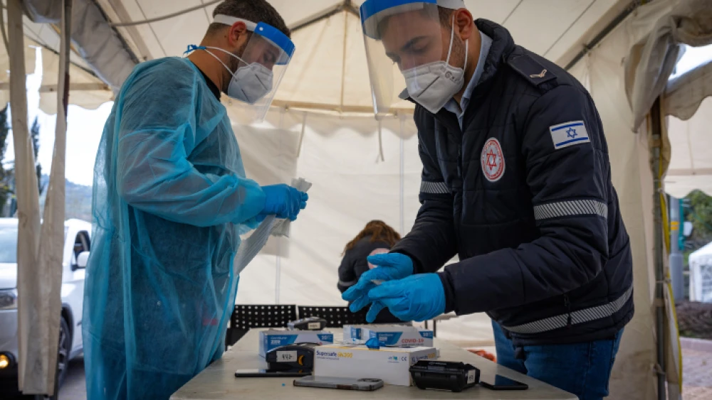Magen David Adom workers at a drive-through COVID-19 testing site in Jerusalem, on March 22, 2022. Photo by Olivier Fitoussi/Flash90.