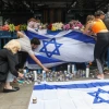 Israelis light candles at the scene of a deadly terror attack, on Dizengoff Street in central Tel Aviv. Photo by Noam Revkin Fenton/Flash90.