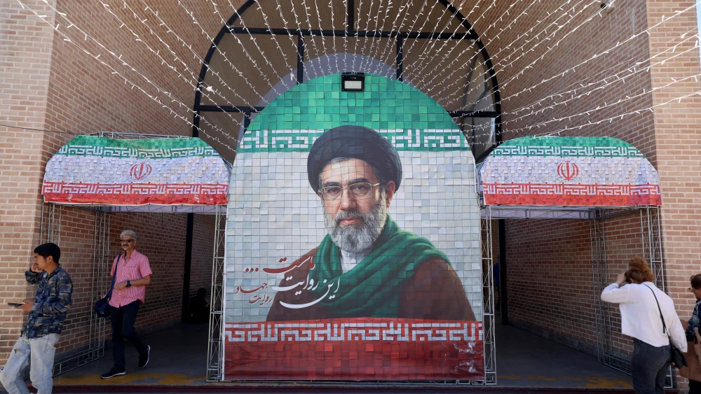 Commuters walk past a large tiled image of Iranian Supreme Leader Ayatollah Mojtaba Khamenei at a metro station in Tehran, May 9, 2026. Photo by Atta Kenare/AFP via Getty Images.