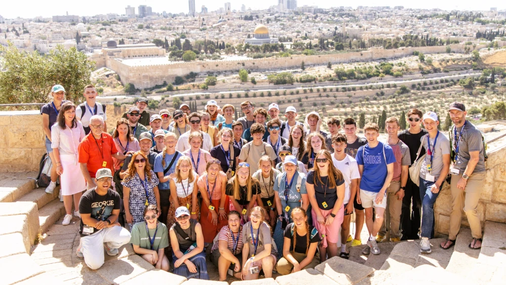 Students on the Passages summer trip 2026 delegation to Israel stop for a group photo overlooking Jerusalem. Photo by Caroline Logan.