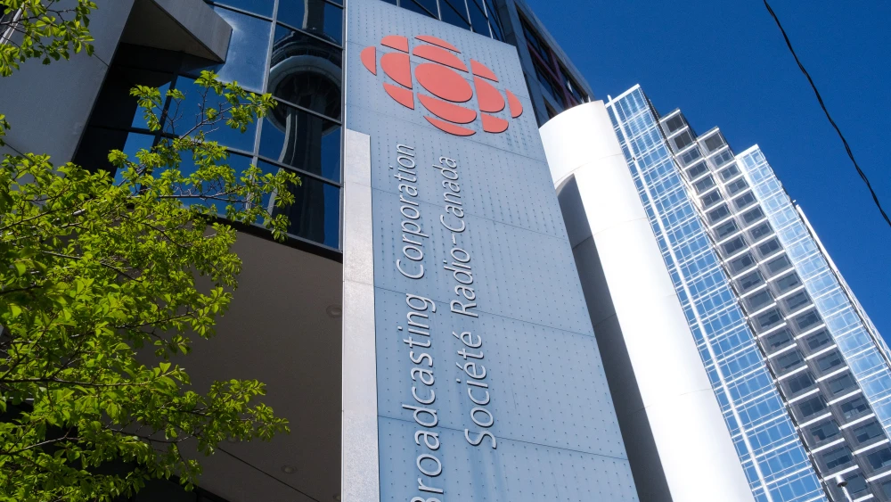Low-angle exterior view of the Canadian Broadcasting Centre with Canadian Broadcasting Corporation and Societe Radio-Canada branding visible on the facade in Toronto, Ontario, Canada on May 5, 2026. Photo by Martin Bertrand / Hans Lucas / AFP via Getty Images.