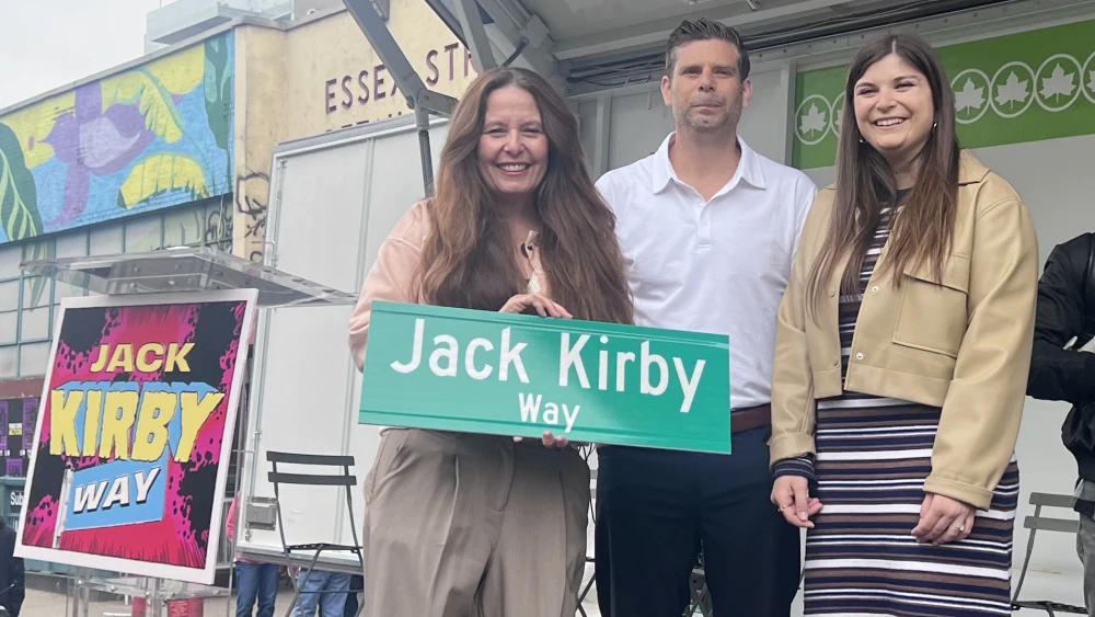 American comic book artist Jack Kirby's grandchildren, (from left to right) Tracy Kirby, Jeremy Kirby and Jillian Kirby, holding the newly unveiled "Jack Kirby Way" street sign, in Manhattan, New York City, May 11, 2026. Photo by Debra Nussbaum Cohen.