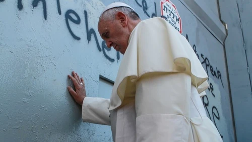 On May 25, 2014, Pope Francis touches the wall that separates Israel from the disputed Palestinian territories on his way to lead a mass in Bethlehem. The pope's stop at the Israeli security fence, which led to a photo op next to anti-Israel graffiti, was unscheduled and ignited a media firestorm. Credit: Nour Shamaly/POOL/Flash90.